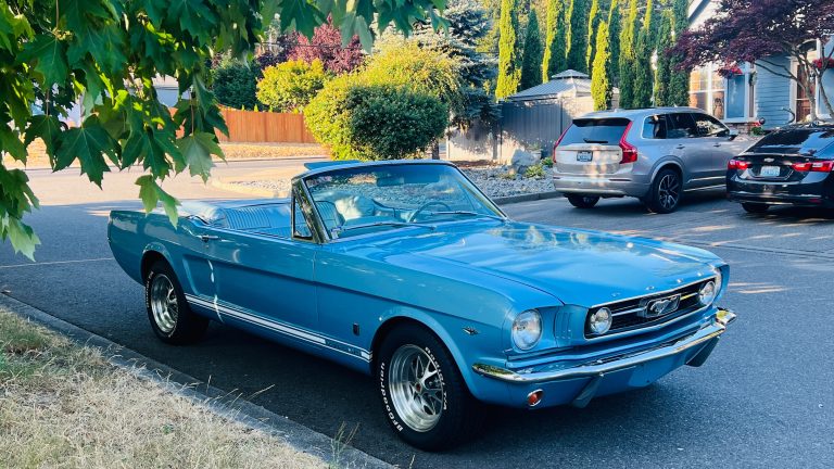 1966 Ford Mustang GT Convertible in Silver Blue, front three quarter view with the top down, parked on a Seattle street