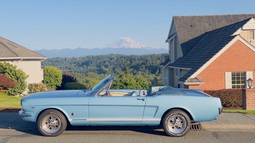 Side profile of a 1966 Ford Mustang GT Convertible in Silver Blue with Mount Rainier in the background
